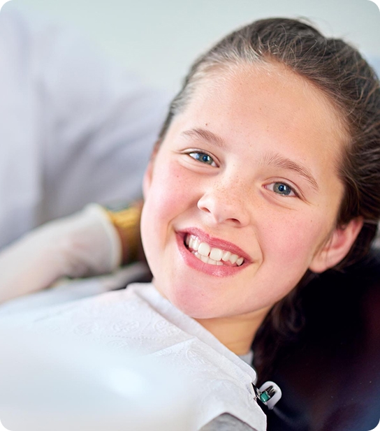 Young child smiling and showing healthy teeth