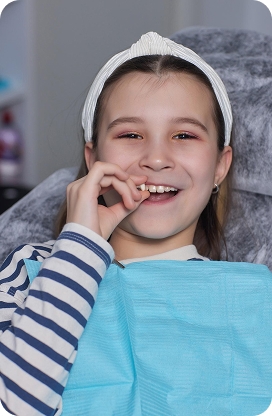 A child smiling and showing healthy teeth