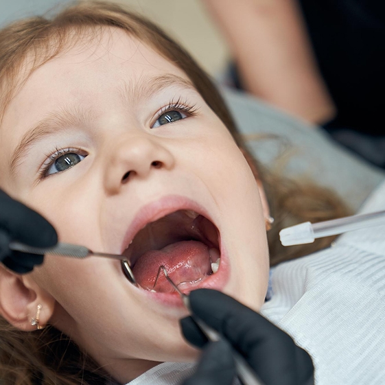 Dentist treating a child during a dental crown visit