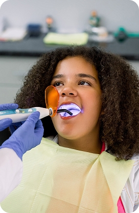 A child smiling and showing healthy teeth