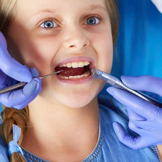 Dentist treating a child during a dental crown visit