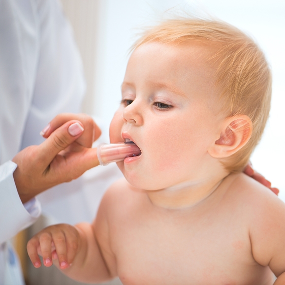 Parent holding a baby at a dental appointment