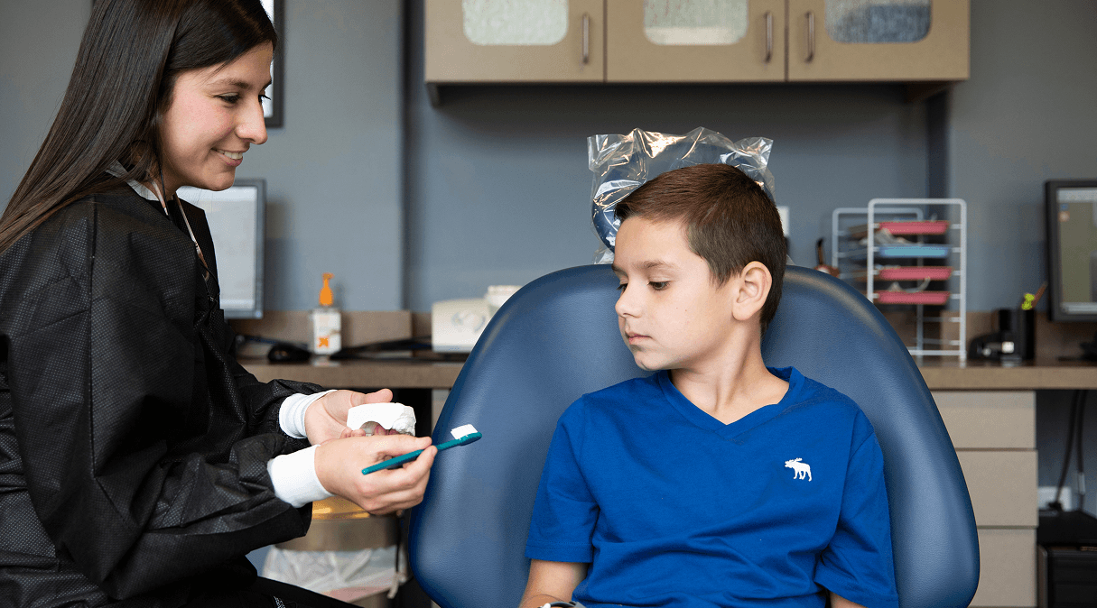 Dr. Brock checking a child’s teeth during an exam