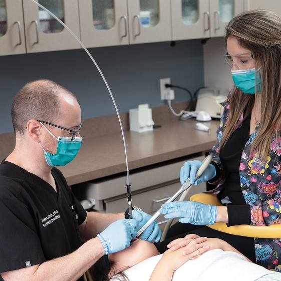 Dentist talking with a teenage patient